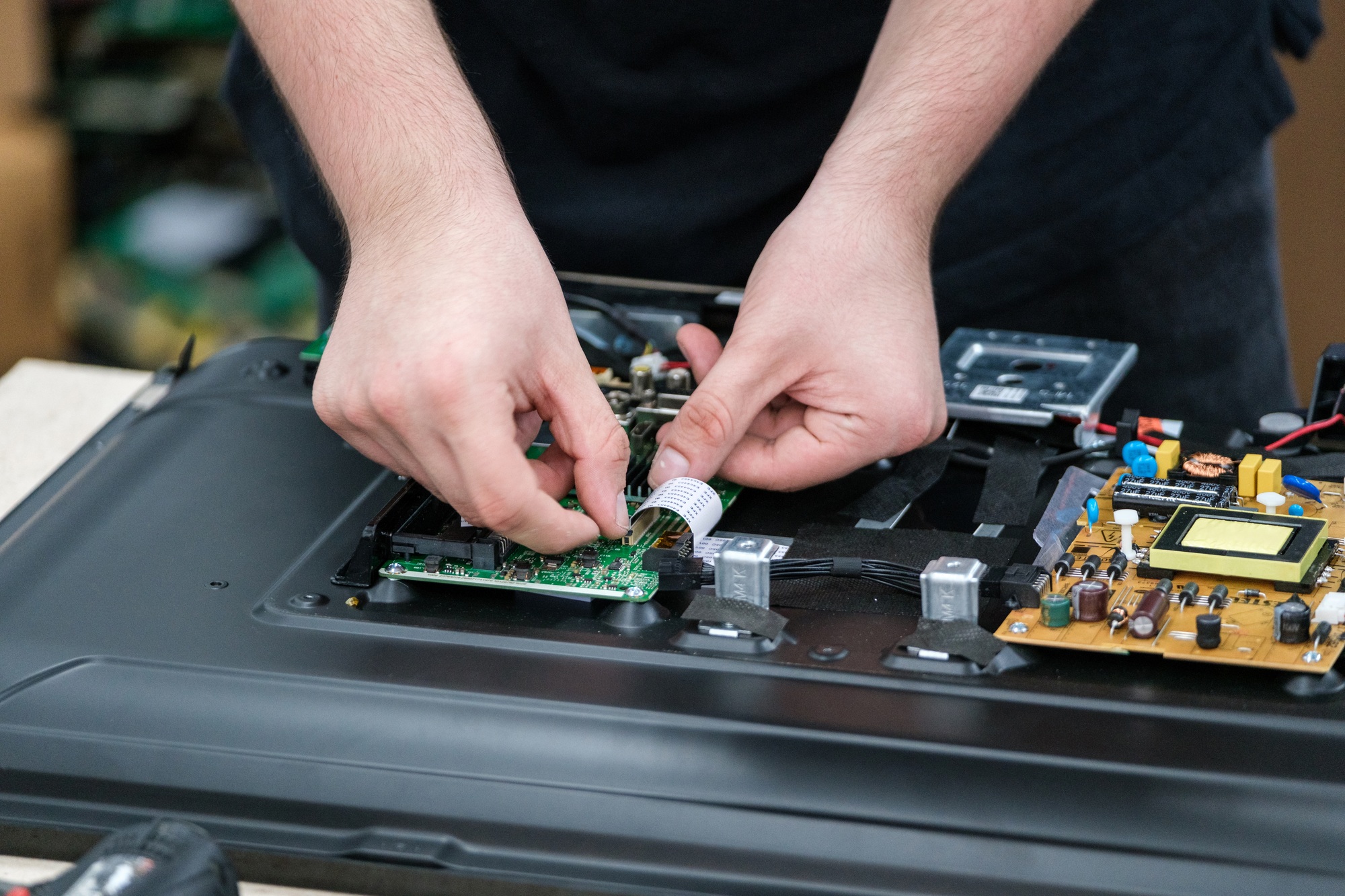 Technician Working on TV Circuit Board for Repair and Maintenance Technician Working on TV Circuit Board for Repair and Maintenance